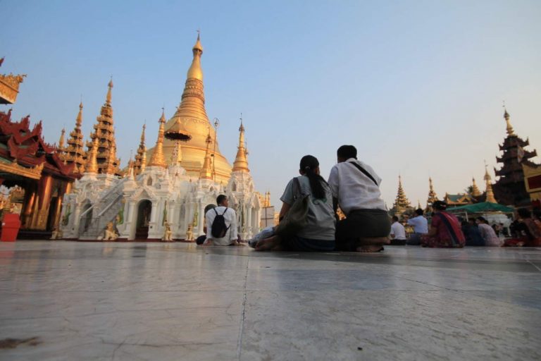 Sitzende Personen vor der Shwedagon Pagode